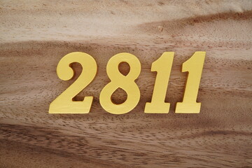 Golden Arabic numerals on a real brown and white wooden floor number 2811