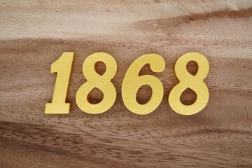 Golden Arabic numerals on a real brown and white wooden floor number 1868