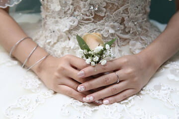 the bride's hand is holding a corsage flower