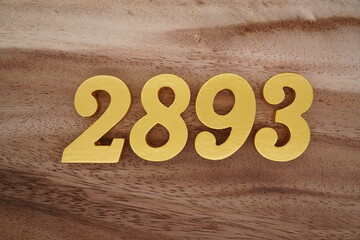 Golden Arabic numerals on a real brown and white wooden floor number 2893