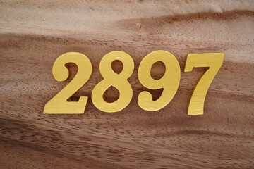 Golden Arabic numerals on a real brown and white wooden floor number 2897