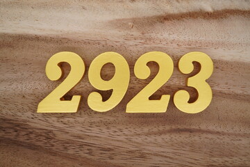 Golden Arabic numerals on a real brown and white wooden floor number 2923