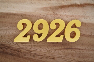 Golden Arabic numerals on a real brown and white wooden floor number 2926