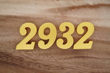 Golden Arabic numerals on a real brown and white wooden floor number 2932