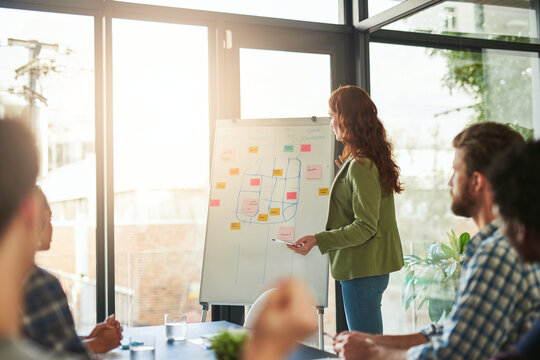 Redesigning their business strategies. Cropped shot of a businesswoman giving a presentation to her coworkers in a modern office.