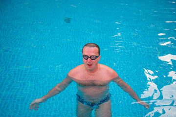sportsman with glasses in the pool trains