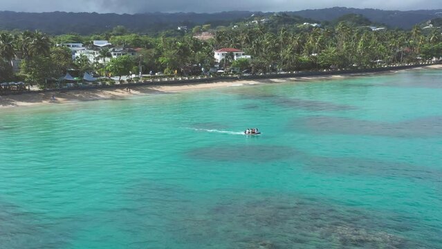 Tourusts have fun on motorboat at Playa Punta Popy, Las Terrenas in Dominican Republic. Aerial view