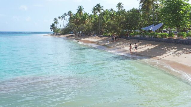 Tourists walking along Playa Punta Popy seashore, Las Terrenas in Dominican Republic. Aerial view