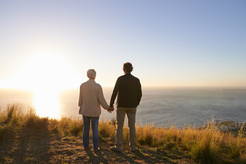 Facing life together. View of a senior couple standing on a hillside together.