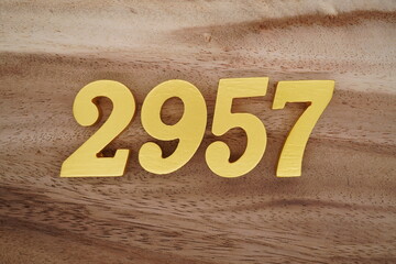 Golden Arabic numerals on a real brown and white wooden floor number 2957