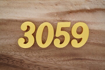 Golden Arabic numerals on a real brown and white wooden floor number 3059