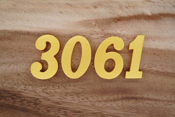 Golden Arabic numerals on a real brown and white wooden floor number 3061