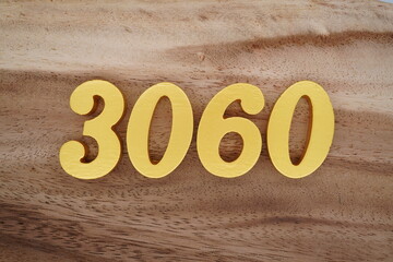 Golden Arabic numerals on a real brown and white wooden floor number 3060
