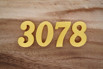 Golden Arabic numerals on a real brown and white wooden floor number 3078