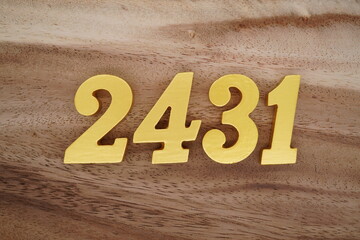 Golden Arabic numerals on a real brown and white wooden floor number 2431