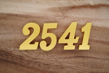 Golden Arabic numerals on a real brown and white wooden floor number 2541