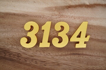 Golden Arabic numerals on a real brown and white wooden floor number 3134