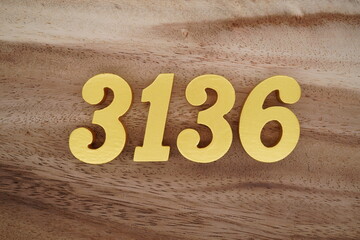 Golden Arabic numerals on a real brown and white wooden floor number 3136