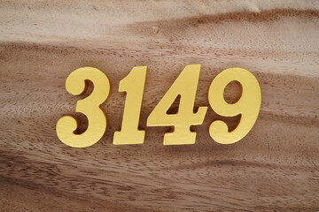 Golden Arabic numerals on a real brown and white wooden floor number 3149
