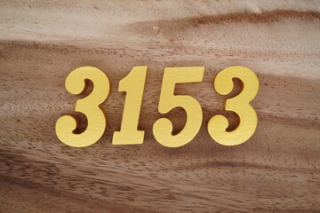 Golden Arabic numerals on a real brown and white wooden floor number 3153