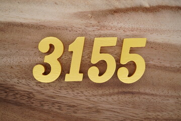 Golden Arabic numerals on a real brown and white wooden floor number 3155
