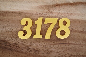 Golden Arabic numerals on a real brown and white wooden floor number 3178