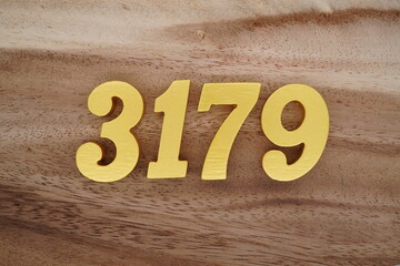 Golden Arabic numerals on a real brown and white wooden floor number 3179