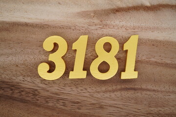 Golden Arabic numerals on a real brown and white wooden floor number 3181