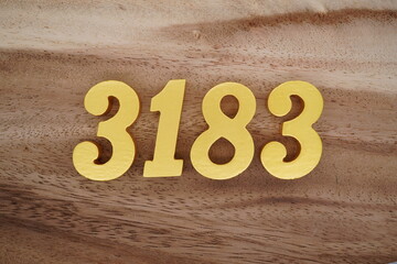 Golden Arabic numerals on a real brown and white wooden floor number 3183