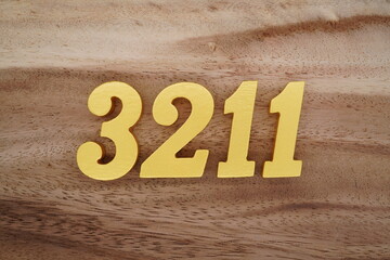 Golden Arabic numerals on a real brown and white wooden floor number 3211
