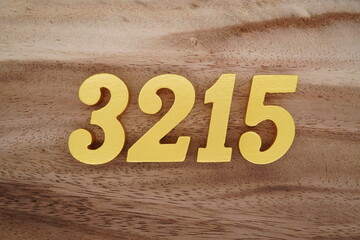 Golden Arabic numerals on a real brown and white wooden floor number 3215