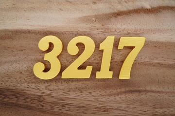 Golden Arabic numerals on a real brown and white wooden floor number 3217