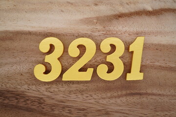 Golden Arabic numerals on a real brown and white wooden floor number 3231