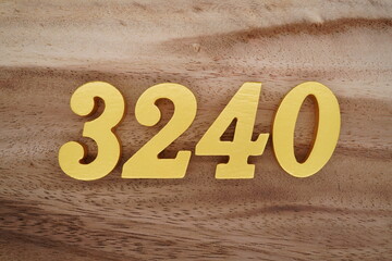 Golden Arabic numerals on a real brown and white wooden floor number 3240