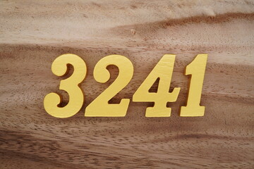 Golden Arabic numerals on a real brown and white wooden floor number 3241