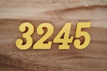 Golden Arabic numerals on a real brown and white wooden floor number 3245