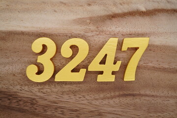 Golden Arabic numerals on a real brown and white wooden floor number 3247