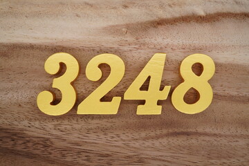 Golden Arabic numerals on a real brown and white wooden floor number 3248