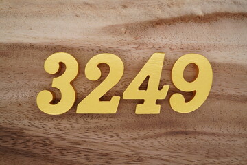 Golden Arabic numerals on a real brown and white wooden floor number 3249