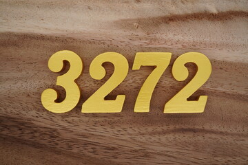 Golden Arabic numerals on a real brown and white wooden floor number 3272