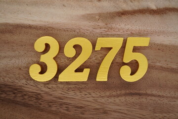 Golden Arabic numerals on a real brown and white wooden floor number 3275