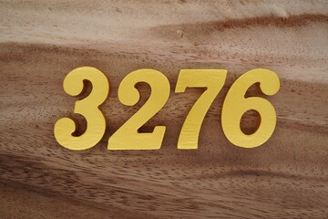Golden Arabic numerals on a real brown and white wooden floor number 3276