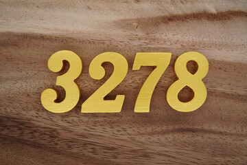 Golden Arabic numerals on a real brown and white wooden floor number 3278