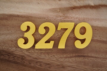 Golden Arabic numerals on a real brown and white wooden floor number 3279
