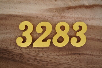 Golden Arabic numerals on a real brown and white wooden floor number 3283