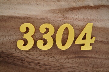 Golden Arabic numerals on a real brown and white wooden floor number 3304