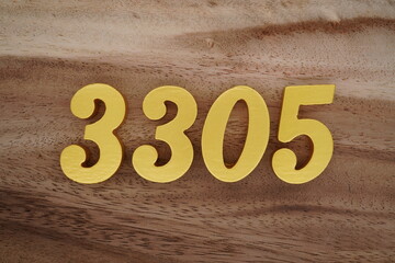 Golden Arabic numerals on a real brown and white wooden floor number 3305
