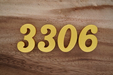 Golden Arabic numerals on a real brown and white wooden floor number 3306