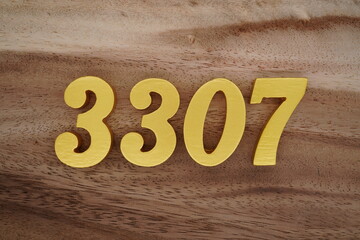 Golden Arabic numerals on a real brown and white wooden floor number 3307