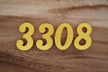 Golden Arabic numerals on a real brown and white wooden floor number 3308